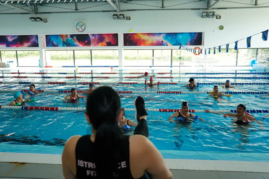 Lezione di acquagym con istruttrice a bordo vasca